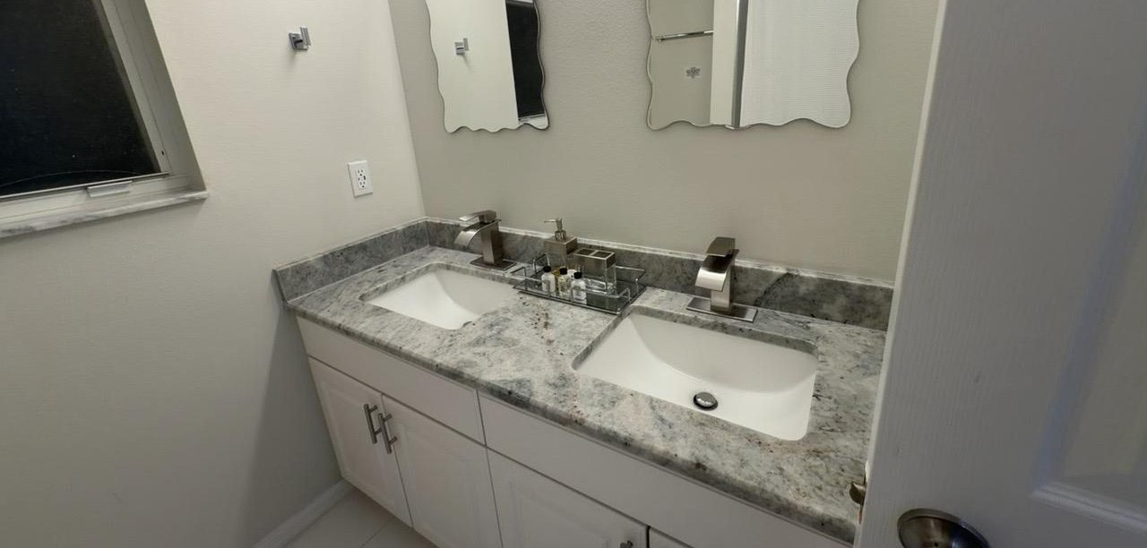 Granite vanity with two sinks, polished fixtures